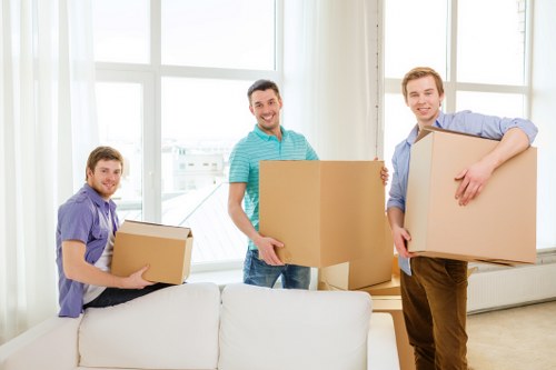 Movers using correct lifting techniques with furniture inside a property